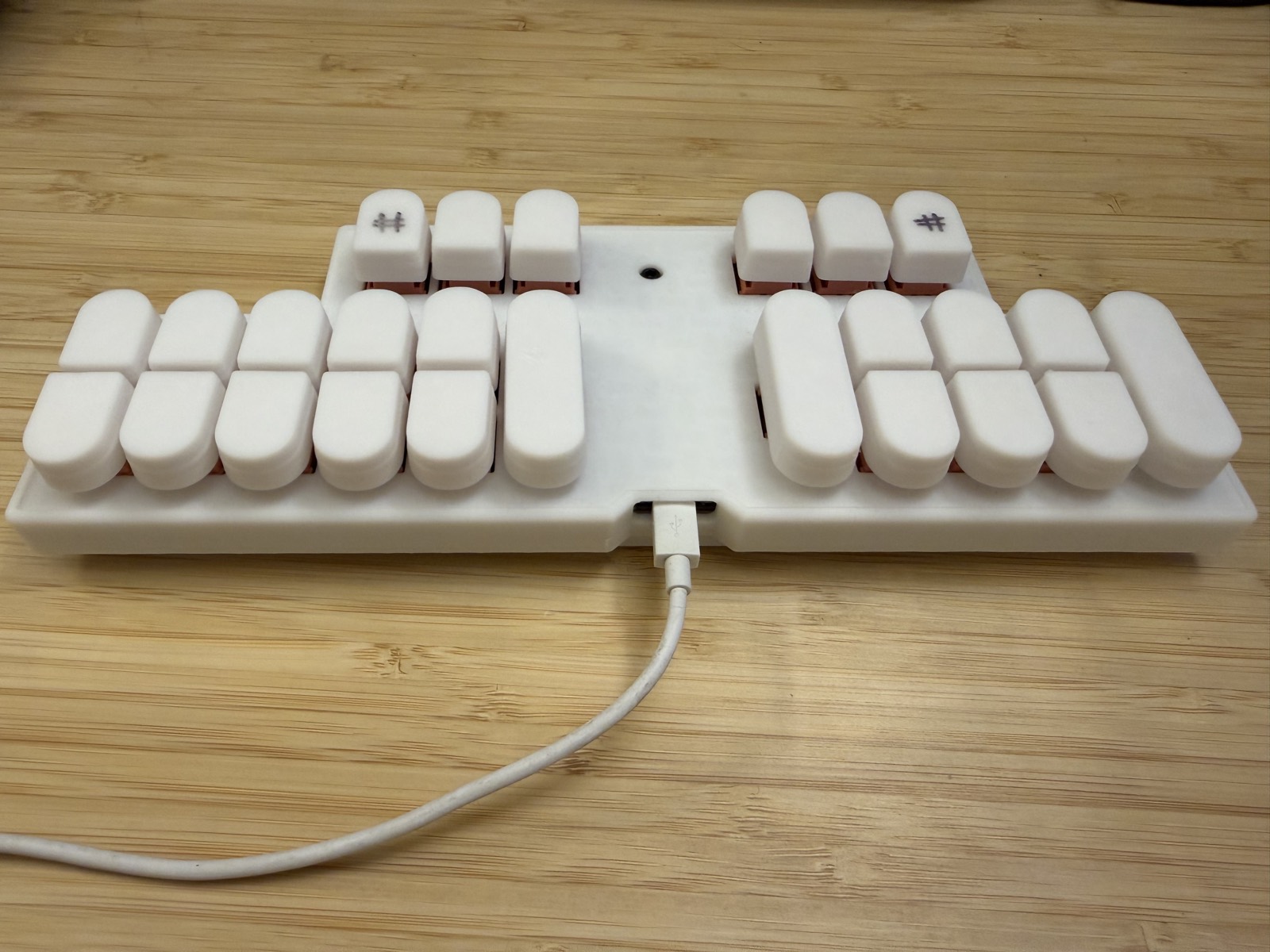 The same steno keyboard at a low three-quarter angle, showing keycap height and the rust-coloured switches under the caps